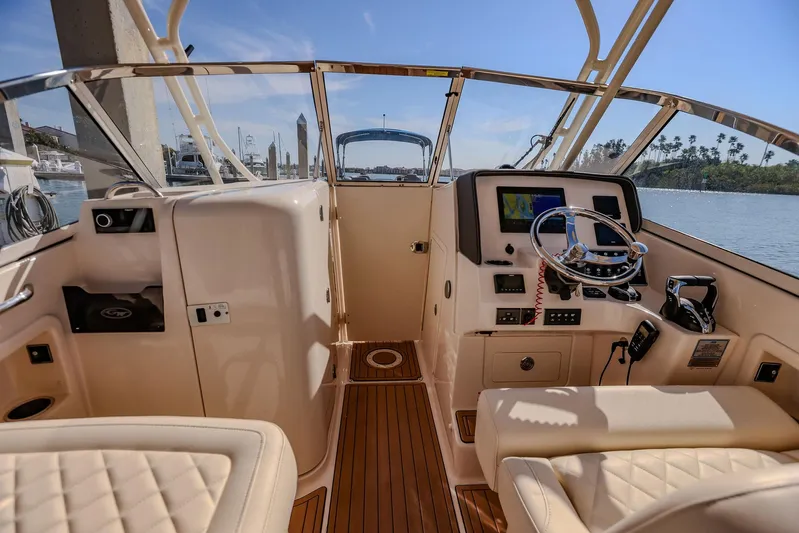 Fin & Tonic Yacht Photos Pics 2024 Grady-White Freedom 275 boat interior with modern dashboard and seating.