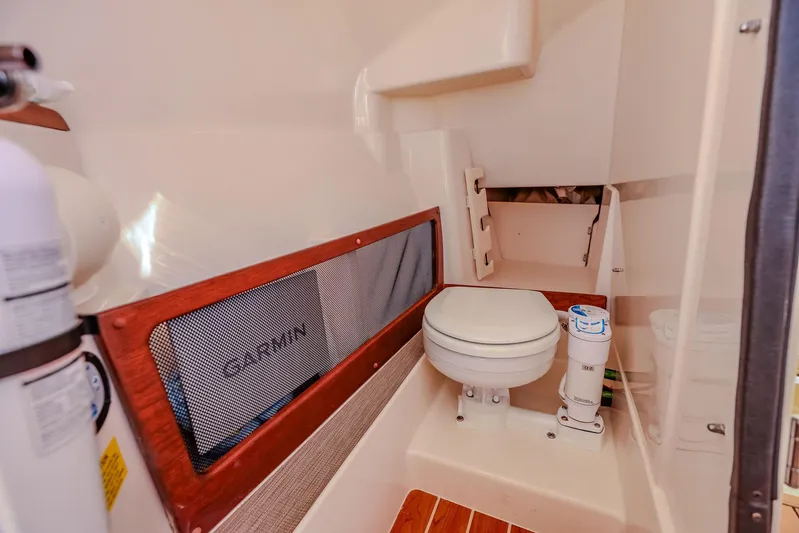 Fin & Tonic Yacht Photos Pics 2024 Grady-White Freedom 275 boat interior with compact marine toilet and storage.