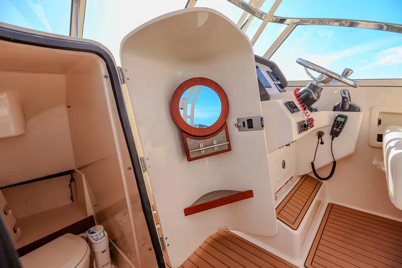 Fin & Tonic Yacht Photos Pics 2024 Grady-White Freedom 275 boat interior with helm and cabin area.