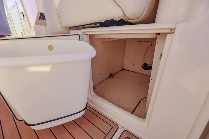 Fin & Tonic Yacht Photos Pics 2024 Grady-White Freedom 275 boat storage compartment with white interior and wooden flooring.