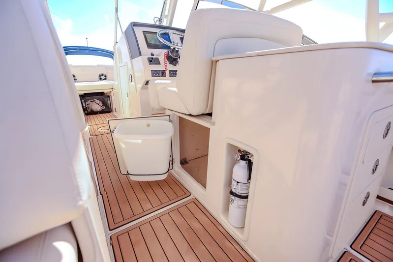 Fin & Tonic Yacht Photos Pics 2024 Grady-White Freedom 275 boat interior with teak flooring and modern helm.