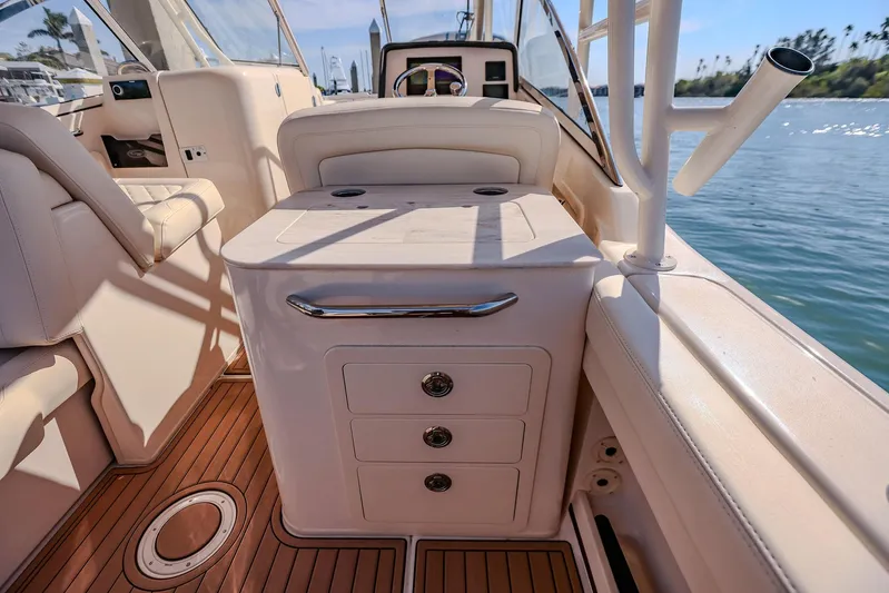 Fin & Tonic Yacht Photos Pics 2024 Grady-White Freedom 275 boat interior with seating and storage, docked by the water.