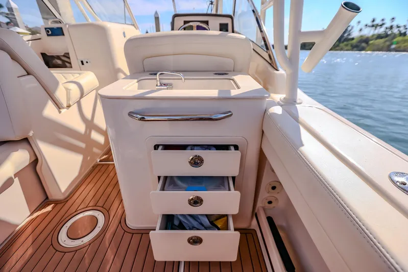 Fin & Tonic Yacht Photos Pics 2024 Grady-White Freedom 275 boat interior with storage drawers and teak flooring.