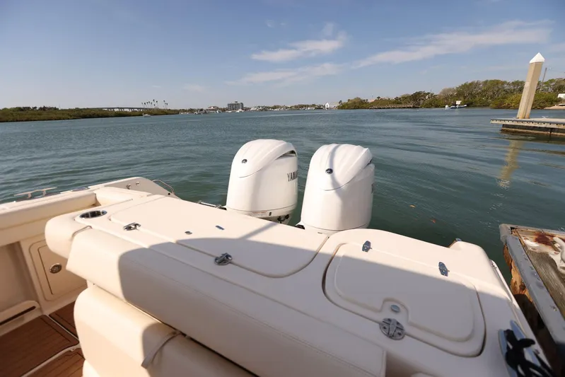 Fin & Tonic Yacht Photos Pics 2024 Grady-White Freedom 275 boat with dual engines on a serene waterway.