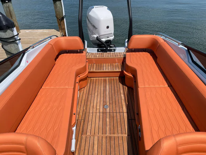 #0063 Bianca Panarea Yacht Photos Pics 2022 Cranchi 26 Rider boat with orange seating and wooden deck, docked by the water.