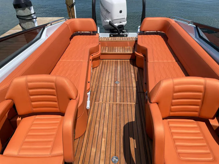 #0063 Bianca Panarea Yacht Photos Pics 2022 Cranchi 26 Rider boat with orange leather seats and wooden deck.