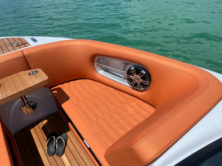 #0063 Bianca Panarea Yacht Photos Pics Luxurious seating on 2022 Cranchi 26 Rider boat with teak flooring and orange upholstery.