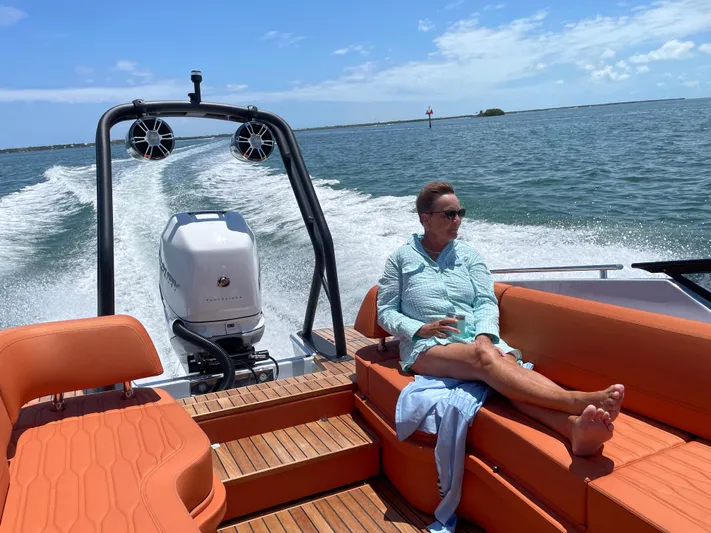 #0063 Bianca Panarea Yacht Photos Pics Person relaxing on a 2022 Cranchi 26 Rider boat, enjoying a sunny day on the water.
