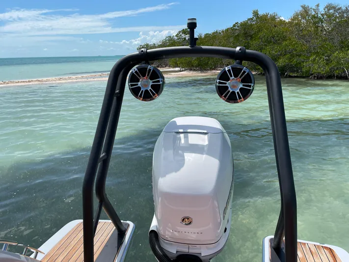 #0063 Bianca Panarea Yacht Photos Pics 2022 Cranchi 26 Rider boat with outboard motor, near tropical shoreline.