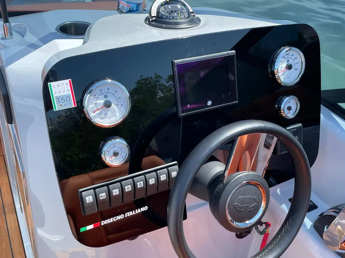 #0063 Bianca Panarea Yacht Photos Pics Dashboard of 2022 Cranchi 26 Rider boat with gauges and steering wheel.