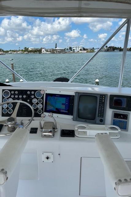 Boat cockpit with navigation equipment, overlooking a scenic waterfront. Post 50, 1999 model.