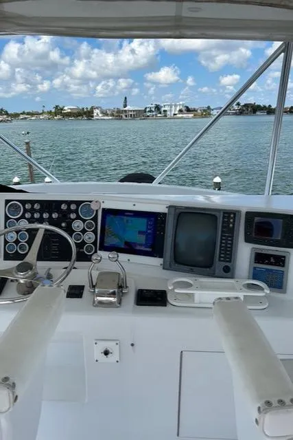 Boat cockpit with navigation equipment, overlooking a scenic waterfront. Post 50, 1999 model.
