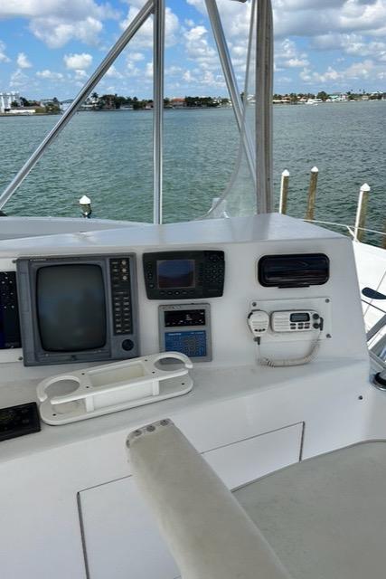 Cockpit of 1999 Post 50 yacht with navigation equipment, overlooking calm waters and blue sky.