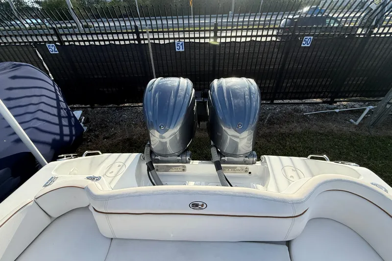  Yacht Photos Pics 2021 Sea Hunt Ultra 305 SE boat with dual outboard engines, parked near a fence.