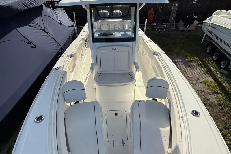  Yacht Photos Pics 2021 Sea Hunt Ultra 305 SE boat interior with seating and console, docked outdoors.