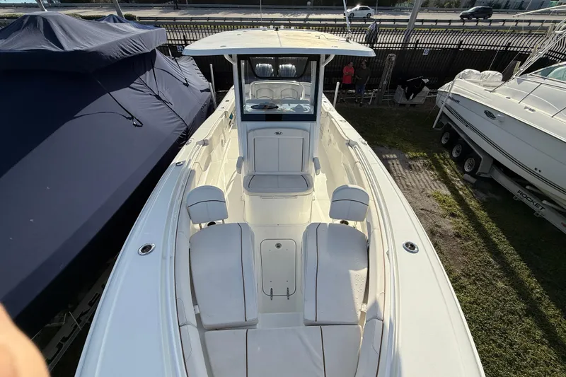  Yacht Photos Pics 2021 Sea Hunt Ultra 305 SE boat, white interior, docked beside covered boats.