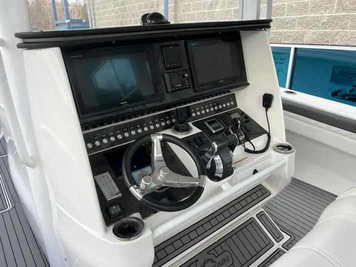 Perseverance Yacht Photos Pics Control panel of a 2019 Fountain 39 NX boat with steering wheel and electronic displays.