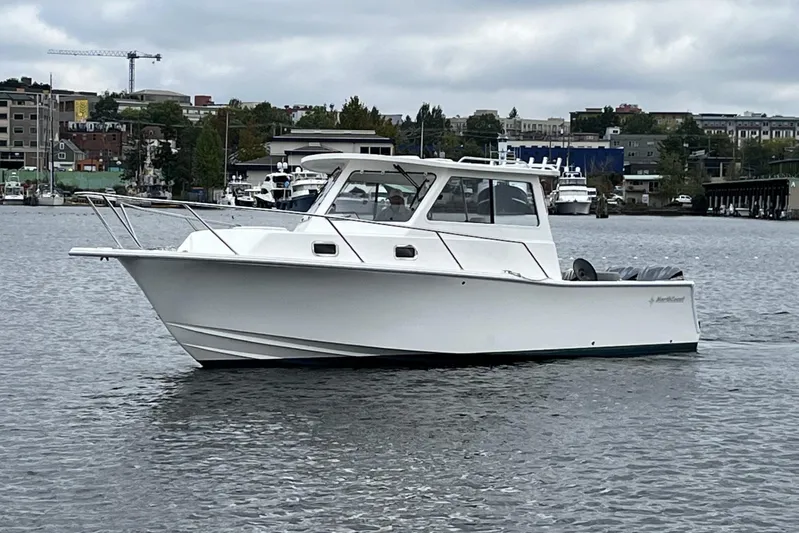  Yacht Photos Pics 2024 NorthCoast 285HT boat on calm water with urban backdrop.