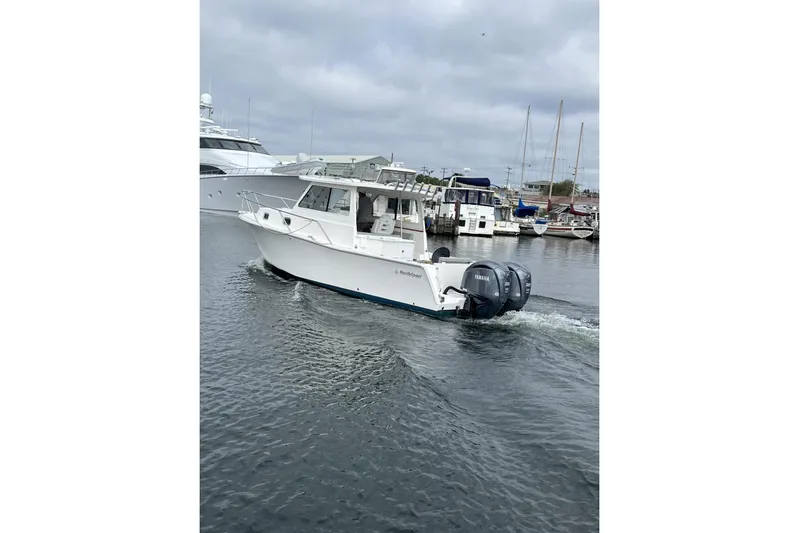  Yacht Photos Pics 2024 NorthCoast 285HT boat cruising in a marina with twin Yamaha engines.