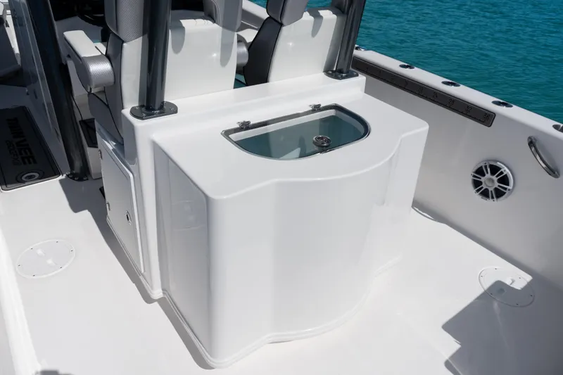  Yacht Photos Pics 2025 Twin Vee 260 GFX2 CC boat interior with seating and storage, on clear blue water.