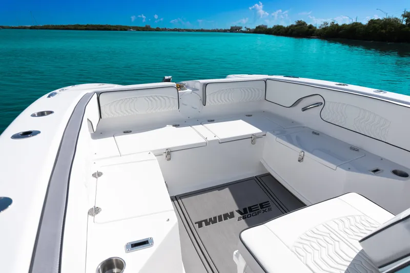  Yacht Photos Pics 2025 Twin Vee 260 GFX2 CC boat interior with white seating and turquoise water backdrop.