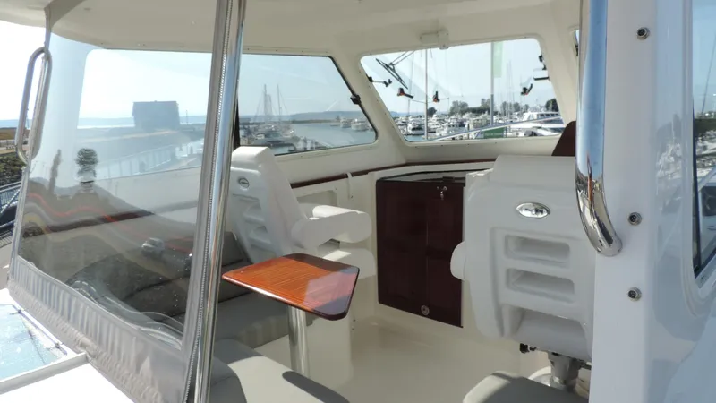  Yacht Photos Pics 2024 NorthCoast 285HT boat interior with seating and table, overlooking marina.