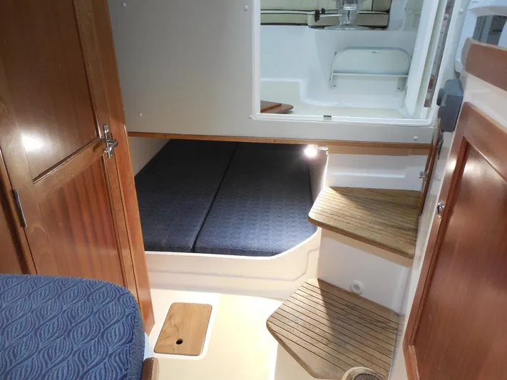  Yacht Photos Pics 2024 NorthCoast 285HT cabin interior with wooden steps and cozy sleeping area.