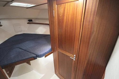  Yacht Photos Pics 2024 NorthCoast 285HT cabin interior with wooden door and cozy sleeping area.