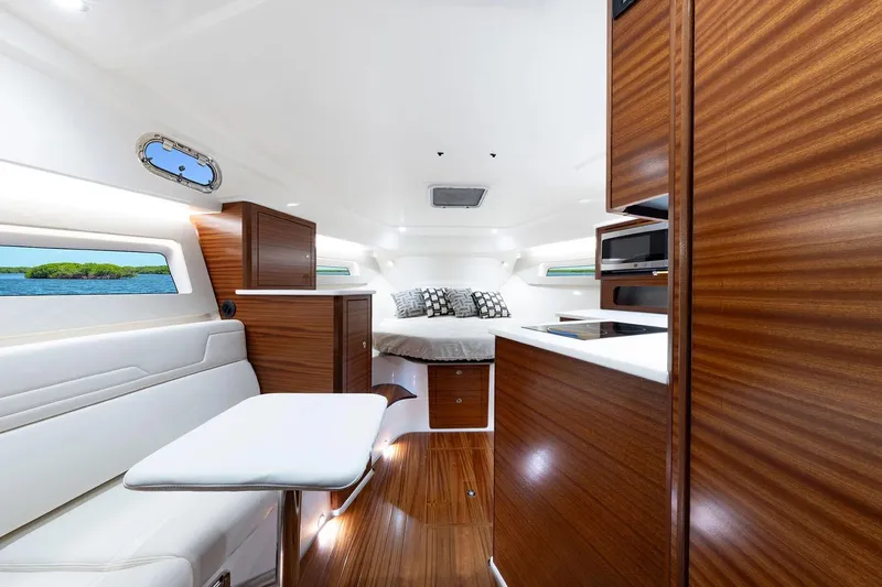  Yacht Photos Pics Manufacturer Provided Image: Luxurious interior of 2025 Pursuit OS 405 Offshore yacht with modern wood finishes.