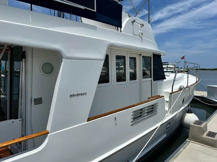 C'est Bon Yacht Photos Pics 2005 Beneteau Swift Trawler 42 docked, showcasing sleek white exterior and wooden accents.