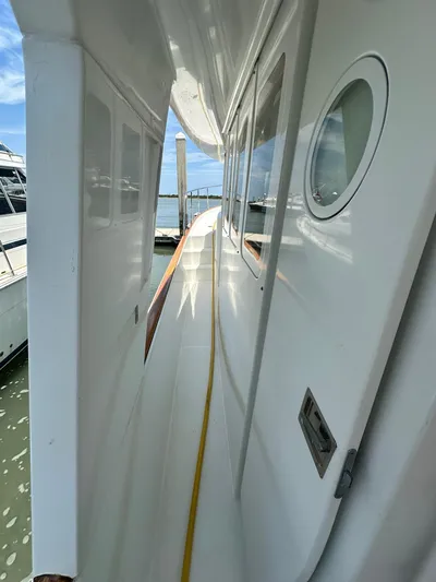 C'est Bon Yacht Photos Pics 2005 Beneteau Swift Trawler 42 side deck view, showcasing sleek design and porthole window.