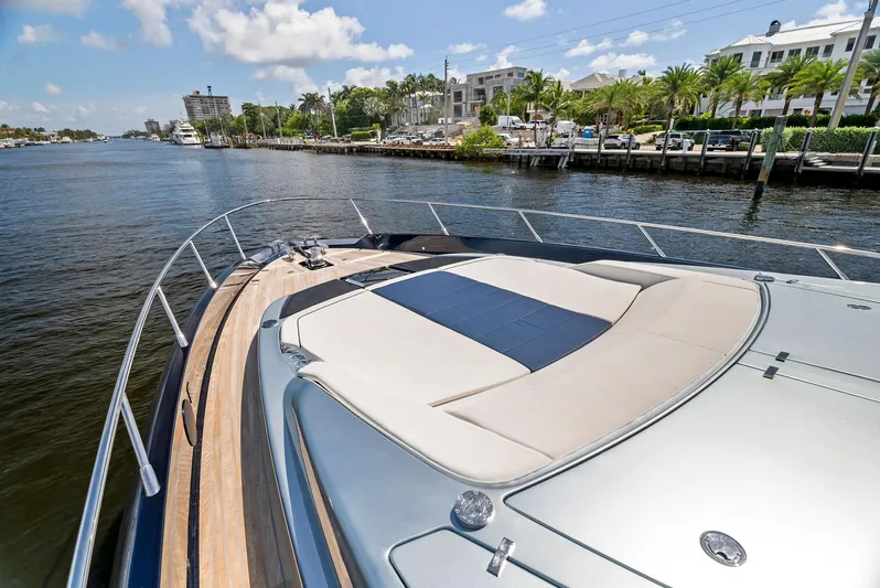 Knot Normal Yacht Photos Pics 2020 Riva 66' Ribelle yacht on a sunny day, docked near luxury waterfront homes.