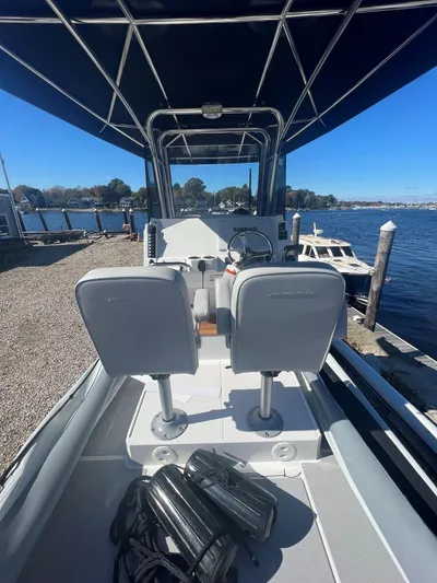  Yacht Photos Pics 2023 Protector 250 Chase boat interior with dual seats, docked by a scenic waterfront.