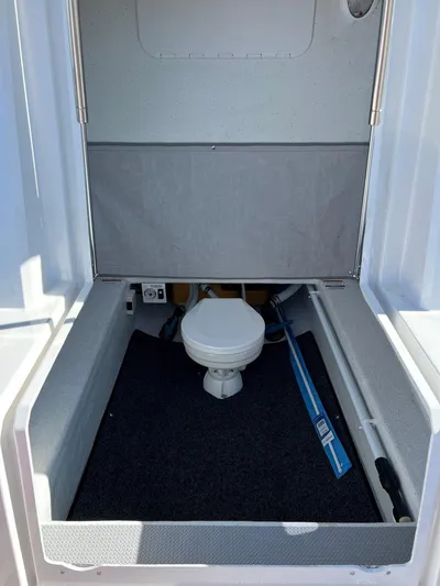  Yacht Photos Pics 2023 Protector 250 Chase boat interior with compact toilet and storage area.