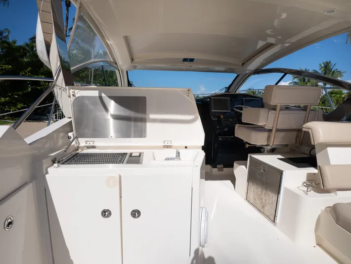 "nameless" Yacht Photos Pics 2014 Pursuit SC 365i Sport Coupe interior with helm, seating, and kitchenette.