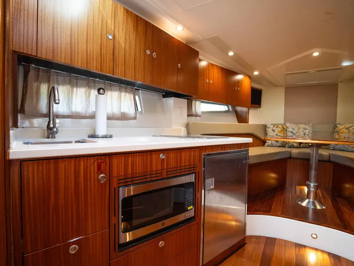 "nameless" Yacht Photos Pics 2014 Pursuit SC 365i Sport Coupe interior with wood cabinetry and modern kitchen amenities.