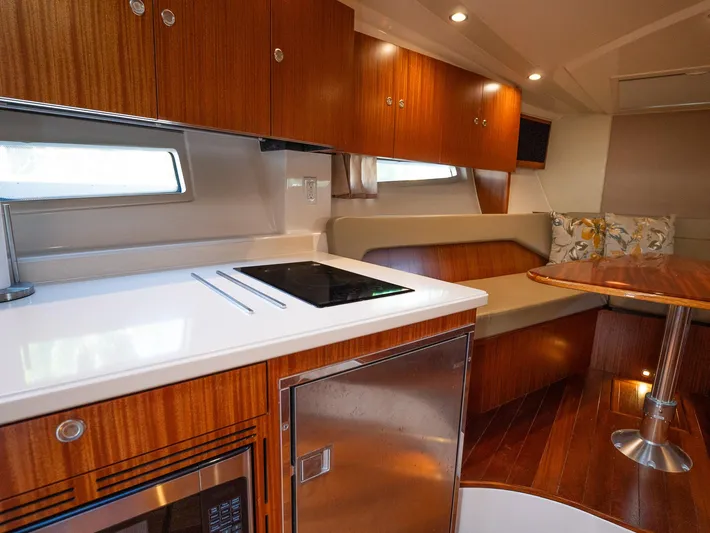 "nameless" Yacht Photos Pics Luxurious interior of 2014 Pursuit SC 365i Sport Coupe with modern kitchen and seating area.