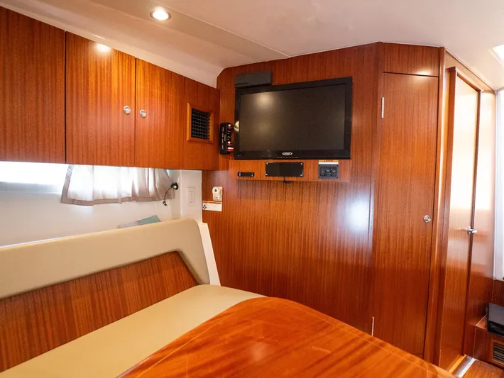"nameless" Yacht Photos Pics Luxurious interior of 2014 Pursuit SC 365i Sport Coupe with wood paneling and TV.