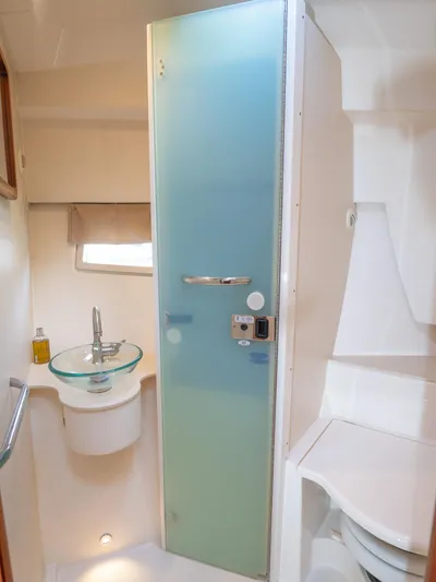 "nameless" Yacht Photos Pics 2014 Pursuit SC 365i Sport Coupe bathroom with frosted glass door and modern sink.