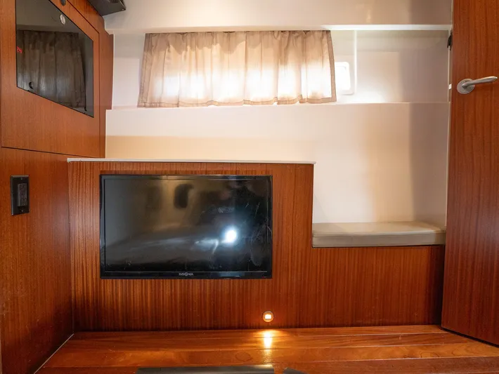 "nameless" Yacht Photos Pics 2014 Pursuit SC 365i Sport Coupe interior with wood paneling and built-in TV.