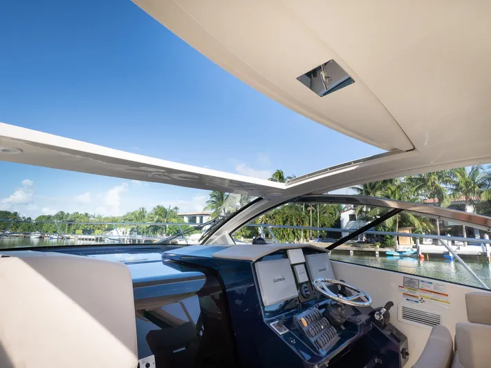 "nameless" Yacht Photos Pics 2014 Pursuit SC 365i Sport Coupe helm with open roof, showcasing marina view.