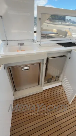  Yacht Photos Pics 2019 Azimut Fly 72 yacht kitchenette with stainless steel appliances and wooden flooring.