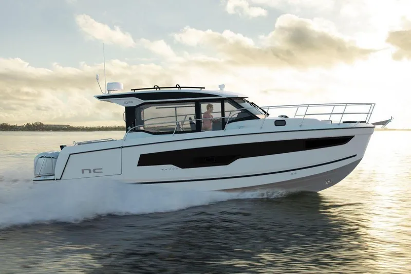  Yacht Photos Pics Manufacturer Provided Image: 2025 Jeanneau NC 1095 Coupe Series 2 cruising on calm waters at sunset.