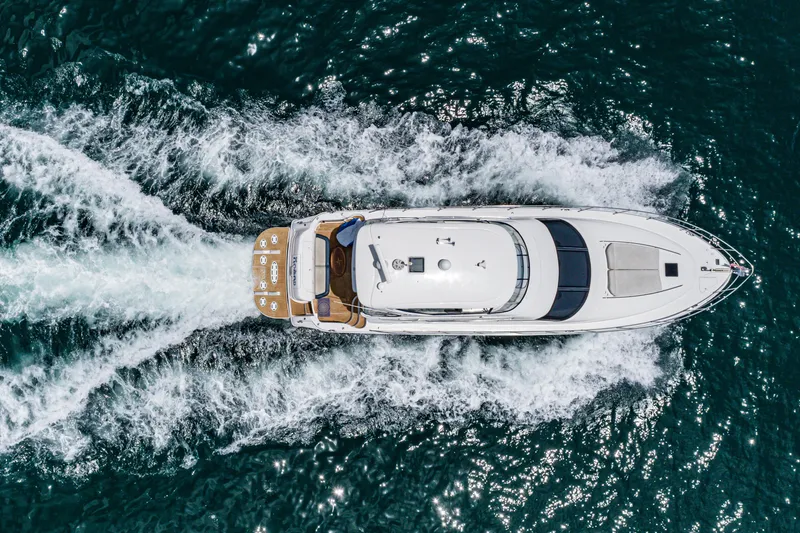 Blue Nomad Yacht Photos Pics Aerial view of 2001 Sea Ray 560 Sedan Bridge yacht cruising on open water.