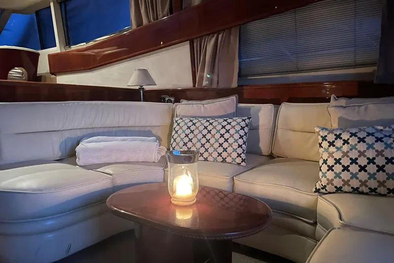  Yacht Photos Pics Luxurious interior of 2000 Princess 56 yacht with cozy seating and candlelit ambiance.