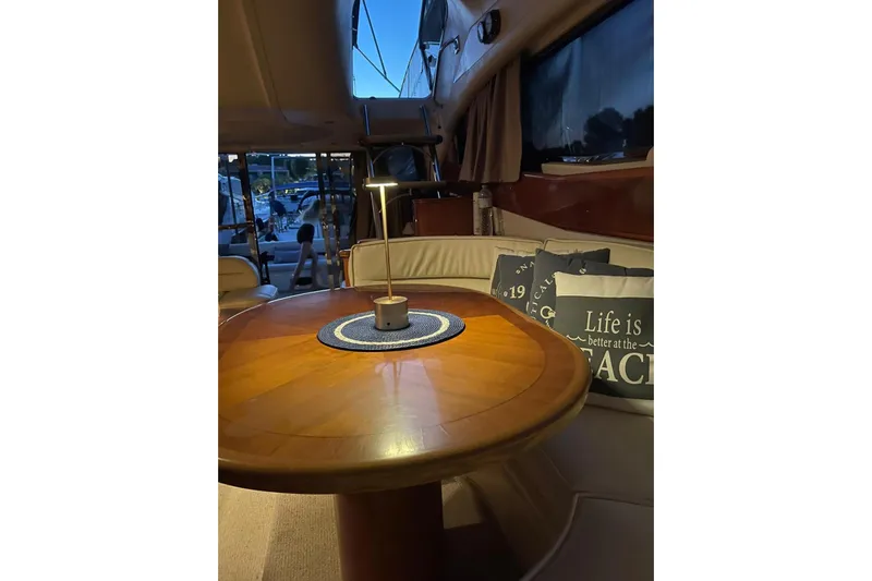  Yacht Photos Pics Cozy interior of 2000 Princess 56 yacht with round table and cushions.