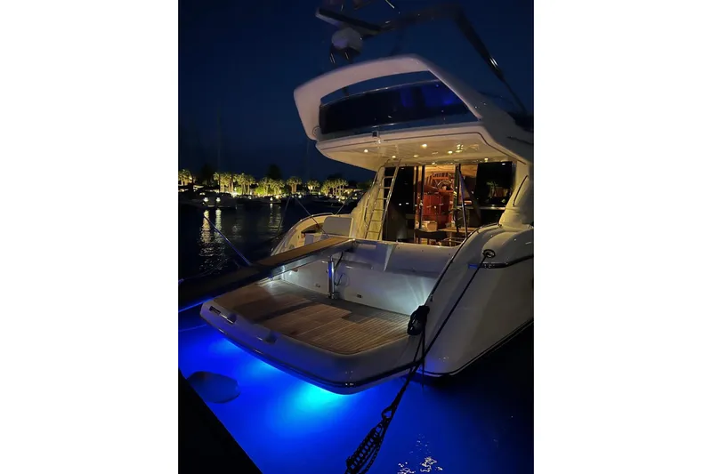  Yacht Photos Pics Luxury yacht Princess 56, 2000 model, illuminated at night with blue underwater lights.