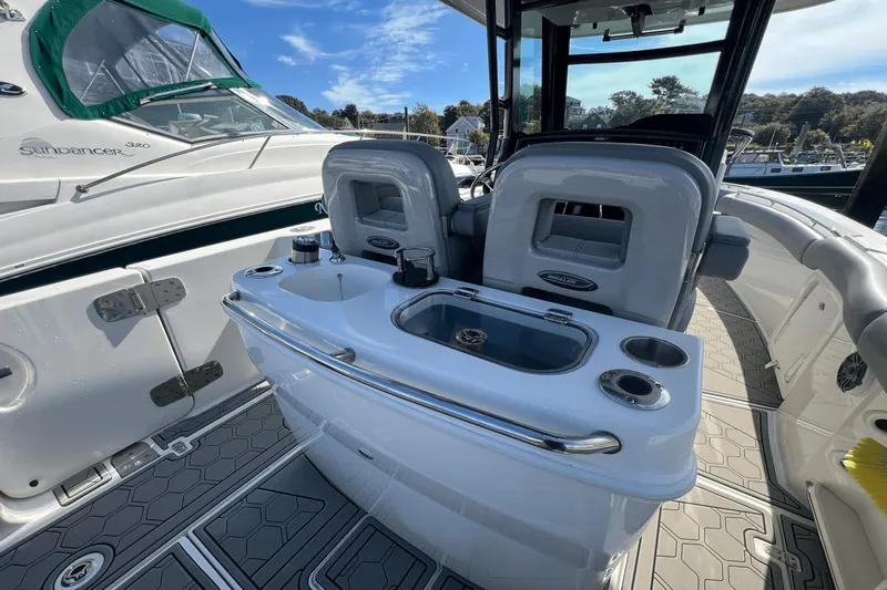  Yacht Photos Pics 2024 Boston Whaler 280 Outrage boat interior with seating and console, docked beside another vessel.