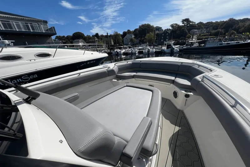  Yacht Photos Pics 2024 Boston Whaler 280 Outrage boat interior at marina, showcasing seating and docked boats.