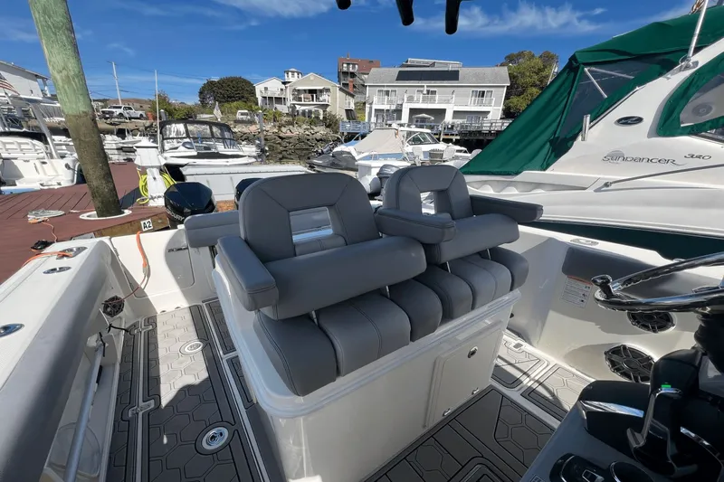 Yacht Photos Pics 2024 Boston Whaler 280 Outrage boat interior with gray seating at a marina.